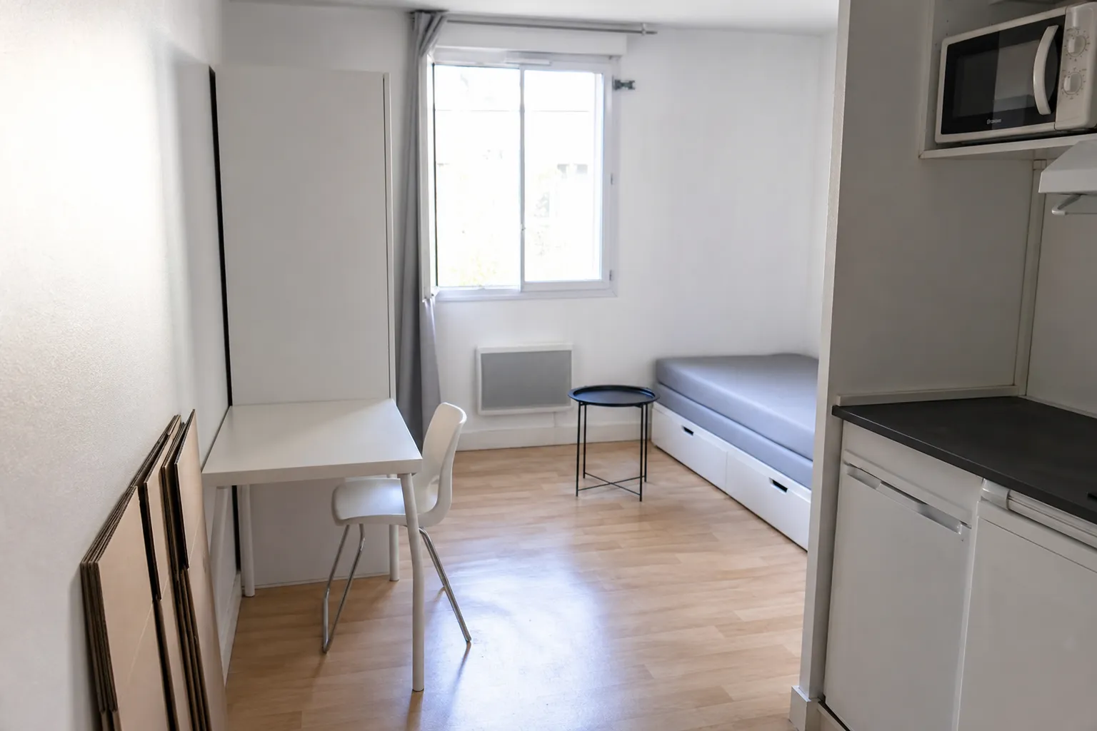 Studio étudiant avec cartons de déménagement pliés